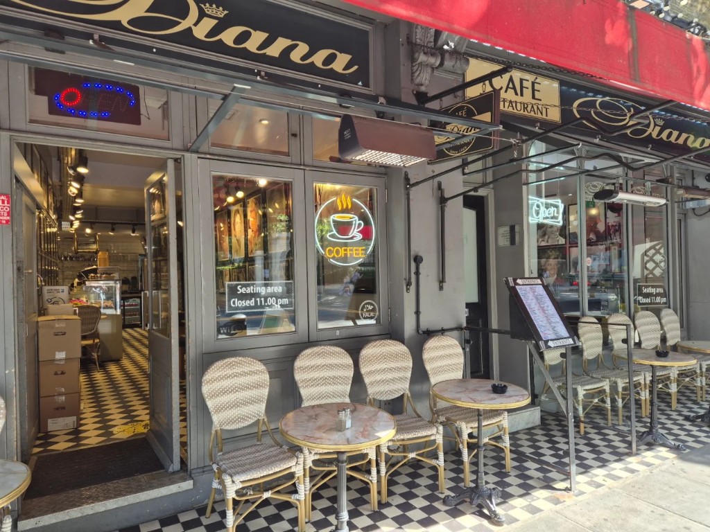 Café Diana storefront with red awning, outdoor seating and black-and-white checkered tiles