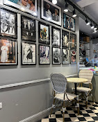 Round bistro table and woven chairs beneath rows of Diana portraits