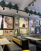 Modern booth seating beside a wall of framed Princess Diana photographs and press cuttings