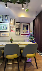 Dining corner with yellow-seat chairs and framed Diana portraits