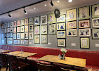Red banquette seating beneath a wall of framed Princess Diana memorabilia