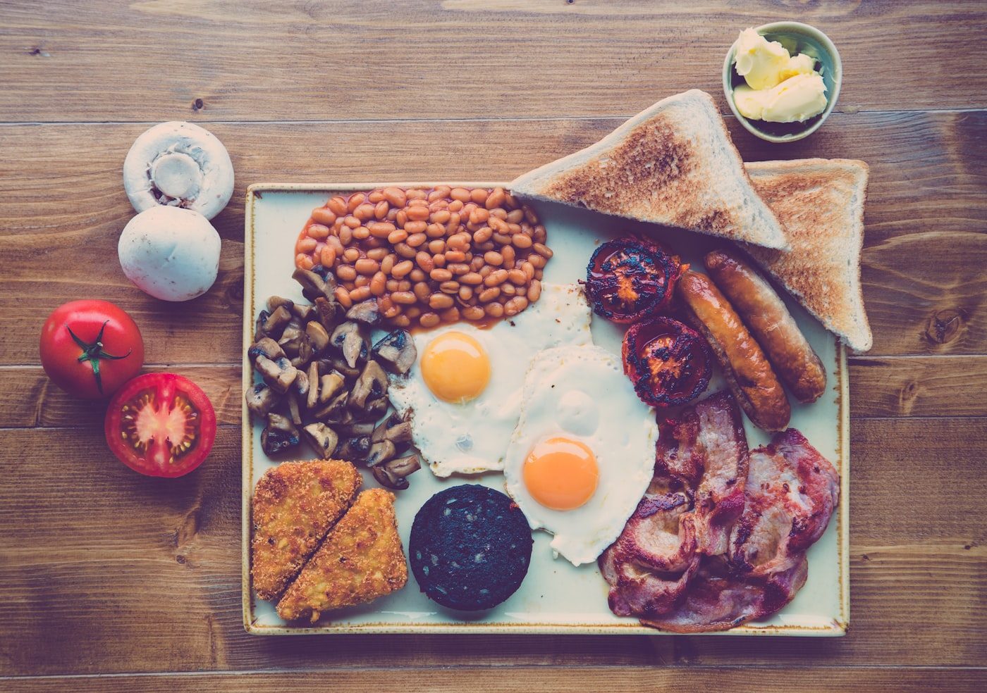 English breakfast with fried egg, ham, beans, toast and tomato