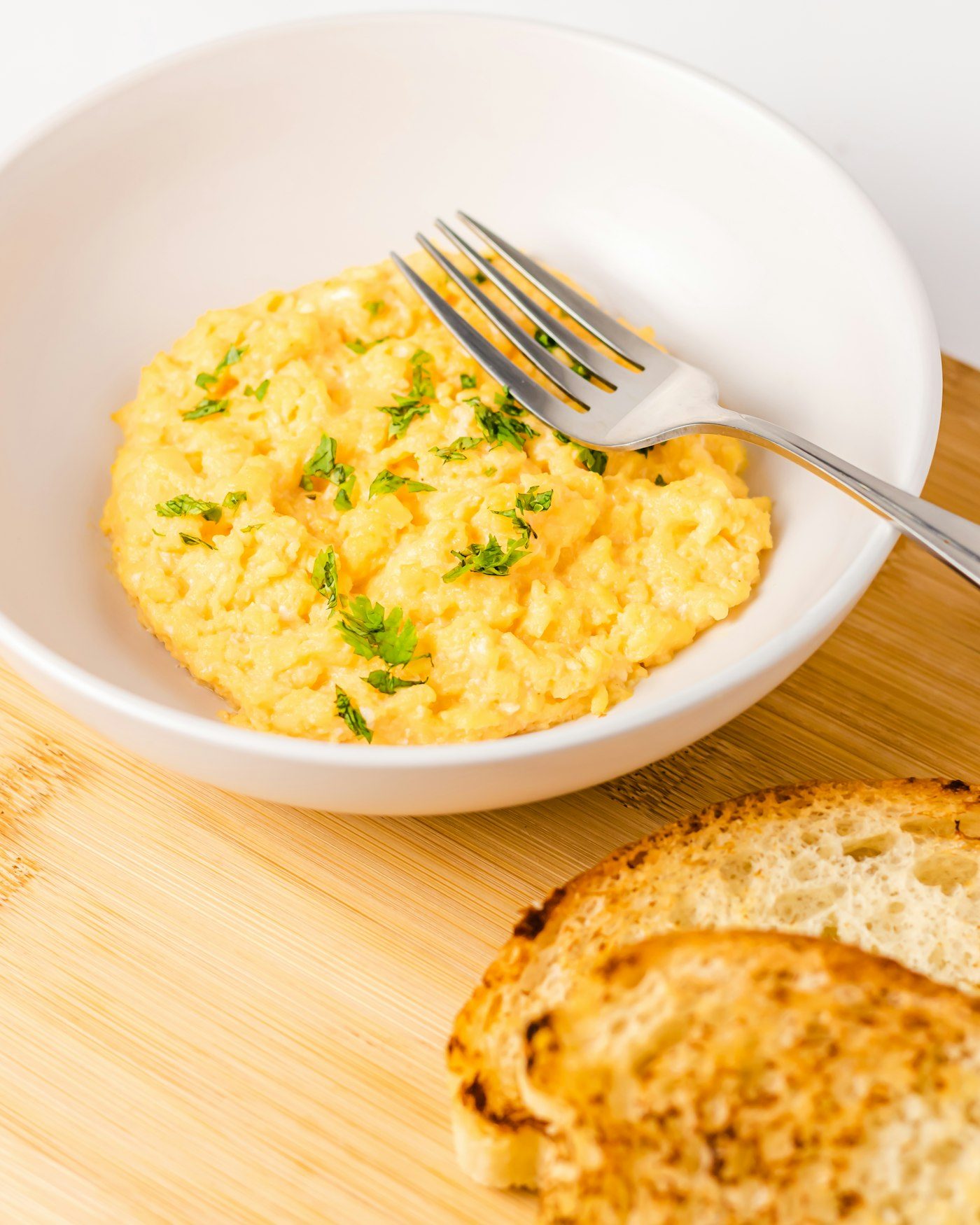 Scrambled eggs in a bowl with toast